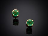 a pair of emerald earrings on a black surface