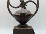 an old fashioned coffee grinder on a wooden base on a white background