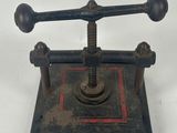 antique cast iron stamper with two screws on a square base