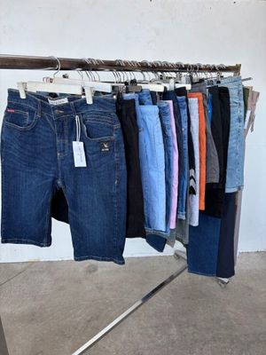 plusieurs paires de jeans suspendues à un portant dans un magasin de vêtements