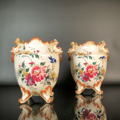 pair of vases with floral designs on them on a black surface
