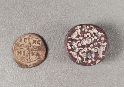 an old coin sitting next to a small coin on top of a table