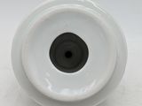 a white vase with a black center sitting on a table