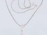 un collier en or blanc orné d'une pierre bleue entourée de diamants