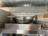 pots and pans sit on a stainless steel shelf in a kitchen