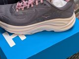 grey and pink sneakers on a blue box in front of a machine