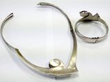 two pieces of jewelry that are on a white surface