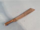 a wooden knife on a white surface next to a toothbrush