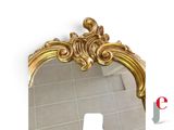 a mirror with a gold frame on the wall