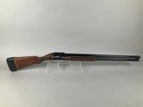 a shotgun with a wooden barrel and a black handle
