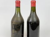 two bottles of wine sitting next to each other on a white surface