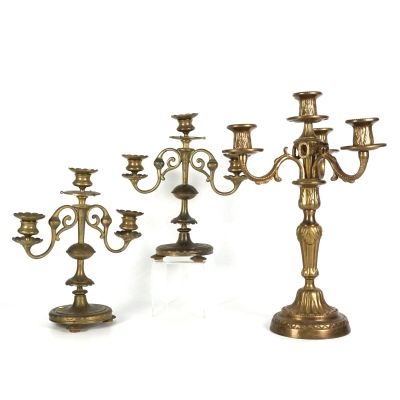 trois chandeliers anciens en laiton avec des bougies, sur fond blanc