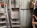 several ladders are stacked next to each other in a room