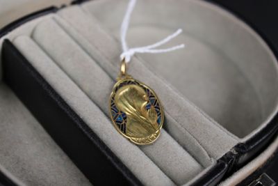 un pendentif en or orné d'un motif bleu et blanc