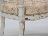 a white chair with a floral upholstered seat