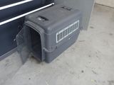 un chien assis à l'intérieur d'une cage pour chien