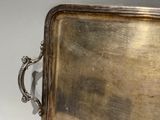 a silver tray with a handle on a table