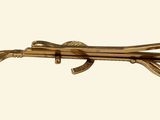 a gold brooch that has a gun on it