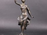 bronze statue of a woman holding a tennis racquet on a marble base