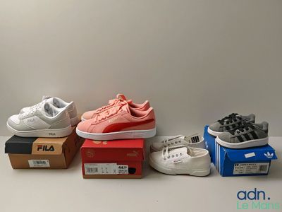 Plusieurs paires de chaussures sont alignées sur une table