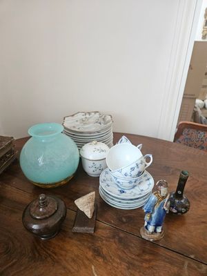 a wooden table with a lot of dishes and cups on it