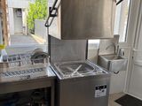une cuisine équipée d'un évier, d'une cuisinière et d'autres éléments