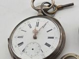 a silver pocket watch with a chain around it