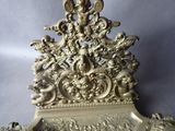 a gold clock with angels and cherensils on it
