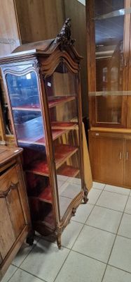 un meuble en bois avec une porte en verre dans une pièce