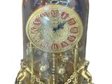 a clock inside of a glass dome with a chain around it
