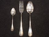 three spoons and a fork on a black surface