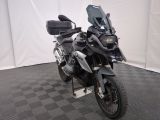 une photo d'une moto noire garée sur un sol à damier