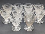 six clear glass goblets sitting on top of a table