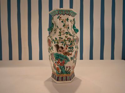 un vase posé sur une table devant un mur rayé