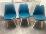 three blue chairs sitting next to each other in a kitchen