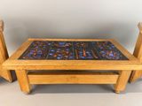 two wooden chairs and a table with a tile on it