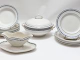 cinq assiettes et un bol posés sur une table blanche