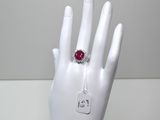 une main sur laquelle est passée une bague sertie d'une pierre rouge