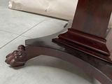 a wooden table with a marble top on a tile floor