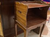 a small wooden desk with a mirror on top of it