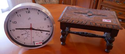 une horloge posée à côté d'un petit tabouret sur une table
