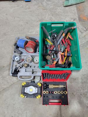 de nombreux outils dans une caisse verte posée par terre