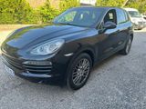 La Porsche Cayenne noire est garée sur le parking.