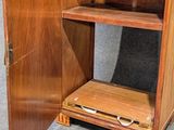 a wooden cabinet with a glass door and a shelf