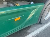 a close up of a green truck with a yellow sticker on it