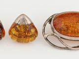 une photo représentant une paire de boucles d'oreilles et une bague ornée d'une grosse pierre d'ambre