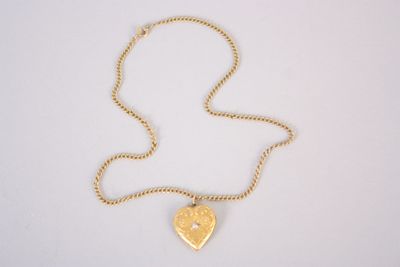 un collier en or avec un pendentif en forme de cœur sur une chaîne
