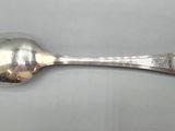 silver plated spoon with a spoon handle on a white surface