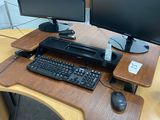 a computer desk with two monitors and a keyboard on it