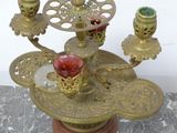 a gold candle holder with a red candle on it